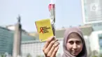 Seorang wanita menunjukkan bunga mawar dan buku panduan saat peringatan Hari AIDS Sedunia di Bundaran HI, Jakarta, Minggu (1/12/2019). Kegiatan ini bertujuan mengedukasi masyarakat tentang penyakit AIDS dan mengajak untuk peduli serta tidak menjauhkan penderita AIDS. (merdeka.com/Iqbal S. Nugroho)