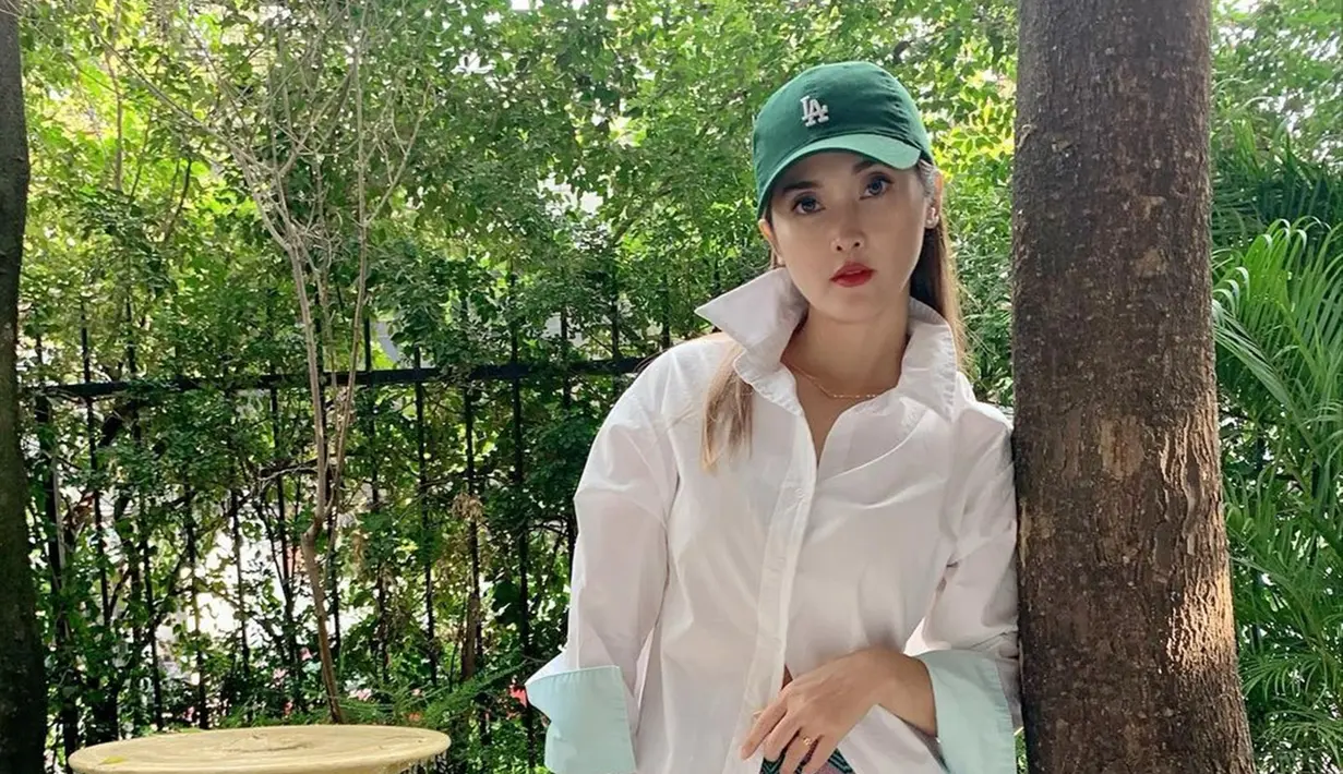 Tampil dengan kemeja berwarna putih, Eva Anindita memilih memadukan penampilannya mengguankan baseball hat berwarna hijau. Penampilan kasualnya ini pun bisa dijadikan inspirasi saat berkumpul dengan teman-teman atau liburan. (Liputan6.com/IG/@eva_anindita_zachrie)