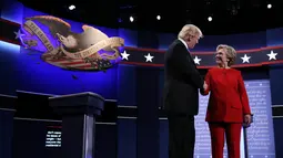 Calon presiden AS dari Partai Republik, Donald Trump dan rivalnya dari Partai Demokrat, Hillary Clinton saling berjabat tangan jelang dimulainya acara debat capres pertama di Hofstra University, New York, Senin (26/9). (REUTERS/Carlos Barria)