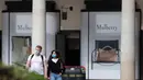 Orang-orang yang mengenakan masker berjalan melewati Covent Garden di London, Inggris, pada 21 September 2020. Menteri Kesehatan Matt Hancock pada Minggu (20/9) mengatakan Inggris mungkin akan menerapkan lebih banyak pembatasan untuk mengatasi penyebaran virus tersebut. (Xinhua/Han Yan)