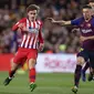 Striker Atletico Madrid, Antoine Griezmann, berusaha melewati pemain Barcelona pada laga La Liga di Stadion Camp Nou, Sabtu (6/4). Barcelona menang 2-0 atas Atletico Madrid. (AP/Manu Fernandez)