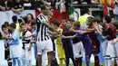 Pemain depan Juventus, Carlos Tevez berjabat tangan dengan anak-anak di akhir pertandingan melawan Cagliari sesaat sebelum memulai selebrasi gelar scudetto di Turin, (18/5/2014). (REUTERS/Alessandro Garofalo)