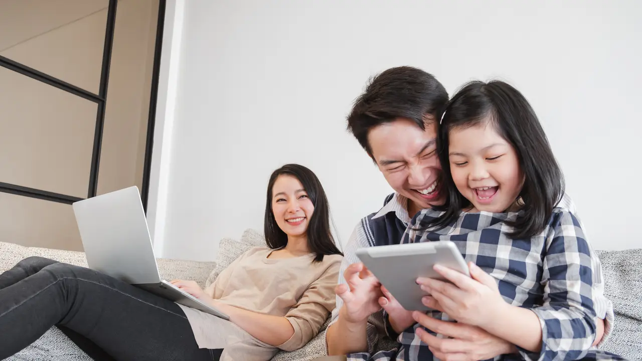 Potret keluarga bahagia menikmati internet super cepat.