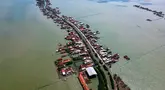 Foto yang diambil pada 30 Juli 2025 menunjukkan pemandangan udara rumah-rumah yang sebagian terendam akibat kehilangan lahan akibat perubahan iklim di Desa Bedono, Demak, Jawa Tengah. (BAY ISMOYO/AFP)