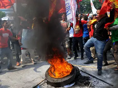 Aksi bakar ban mewarnai demonstrasi terkait RUU Pilkada di depan Gedung DPR, Jakarta, (25/9/14). (Liputan6.com/Johan Tallo)