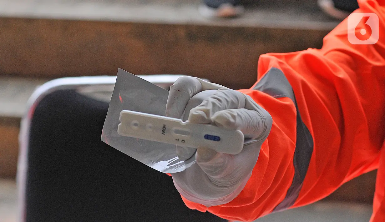 Petugas menunjukkan hasil tes cepat (rapid test) pendektesian COVID-19 kepada tenaga medis di Stadion Patriot Candrabhaga, Bekasi, Jawa Barat, Rabu (25/3/2020). Pemeriksaan hanya diperuntukan bagi tenaga medis seluruh puskesmas, dan rumah sakit yang ada di Kota Bekasi. (Liputan6.com/Herman Zakharia)