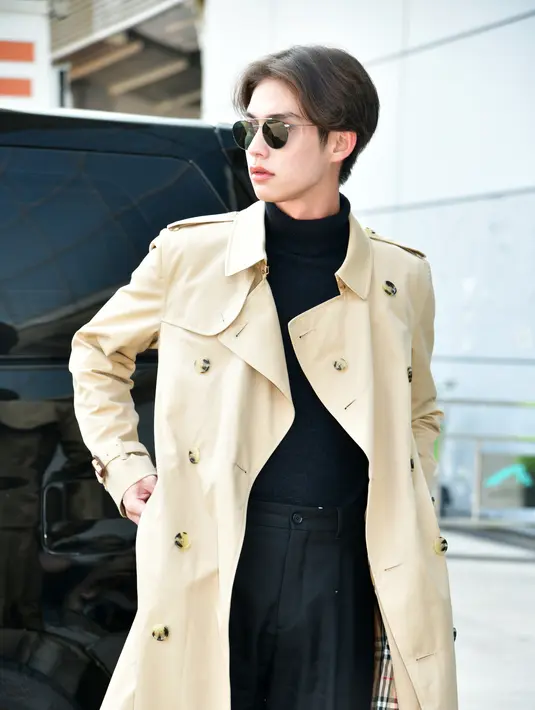 Bright Vachirawit mengenakan Kensington Heritage Trench Coat dan Celana Twill Kaki Lebar di Bandara Internasional Hong Kong pada 19 Februari. [Burberry]