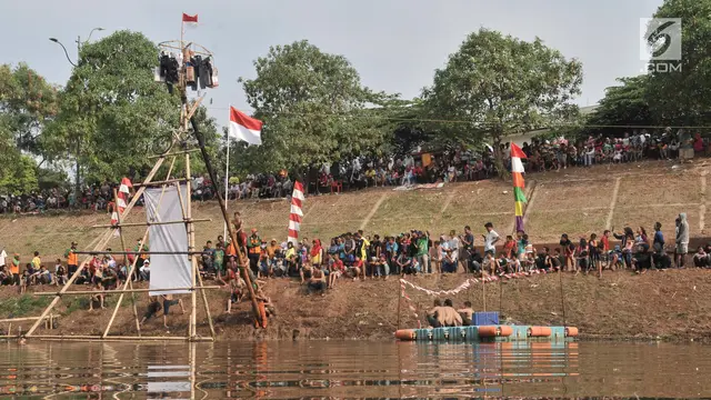 Keseruan Lomba Panjat Pinang di Kanal Banjir Timur
