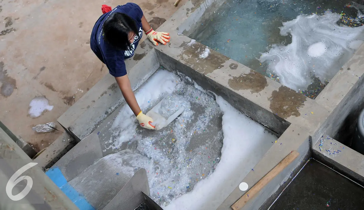 Pekerja menyaring sampah plastik yang telah terpotong potong di Perumahan Vida, Bekasi(19/3). Limbah botol plastik dimanfaatkan menjadi bahan mentah yang bernilai ekonomis dan mengurangi dampak pencemaran lingkungan. (Liputan6.com/Gempur M Surya)