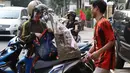 Pedagang menaikkan parsel dagangannya ke sepeda motor pembeli di kawasan Cikini, Jakarta, Rabu (6/6). Menjelang Hari Raya Idul Fitri, penjualan parsel para pedagang dadakan tersebut meningkat hingga 50 persen. (Liputan6.com/Immanuel Antonius)