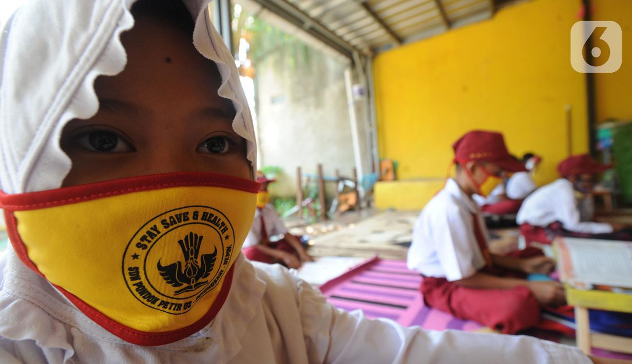 Murid kelas III SDN 02 Pondok Petir mengikuti kegiatan belajar mengajar di teras rumah salah satu siswa di Depok, Senin (31/08/2020). Sudah hampir dua minggu ini, mereka mengadakan pembelajaran secara tatap muka dengan guru yang berkeliling atas permintaan wali murid. (merdeka.com/Arie Basuki)