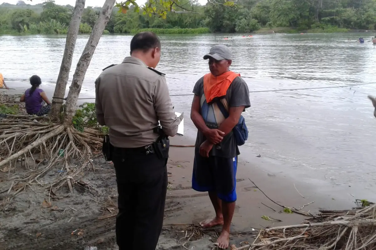 Seorang petugas kepolisian tengah melakukan identifikasi korban yang hilang di muara Sungai Cibaluk, Garut