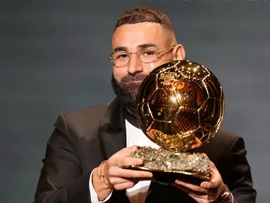 Pemain Real Madrid, Karim Benzema mengangkat trofi Ballon d'Or 2022 di Theater du Chatelet, Paris, Prancis, Senin (17/10/2022). Karim Benzema terpilih sebagai pemenang Ballon d'Or 2022 pada malam penghargaan yang digelar di Theatre du Chatelet, Paris, Perancis, Selasa (18/10/2022) dini hari WIB waktu Indonesia. (AP Photo/Francois Mori)