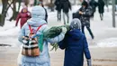 Orang-orang membawa pohon untuk perayaan Tahun Baru dari sebuah pasar di pusat kota Moskow, Rusia (27/12/2020). (Xinhua/Maxim Chernavsky)