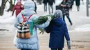 Orang-orang membawa pohon untuk perayaan Tahun Baru dari sebuah pasar di pusat kota Moskow, Rusia (27/12/2020). (Xinhua/Maxim Chernavsky)