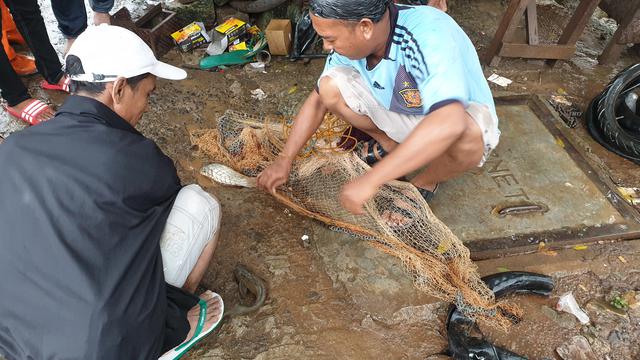Warga Cipinang Manfaatkan Banjir untuk Menangkap Ikan