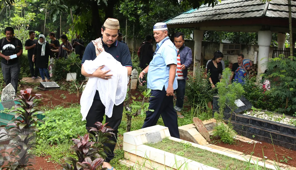 Indra Bekti menggendong jenazah anak ketiganya, Kenward Athar Indrabekti, menuju TPU Kamboja, Radio Dalam,  Jakarta, Rabu (1/2). Istri Bekti, Aldilla Jelita, melahirkan saat usia kandungannya baru mencapai lima bulan. (Liputan6.com/Herman Zakharia)