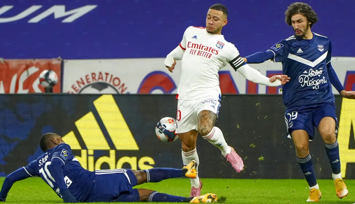 Pemain Lyon Memphis Depay (tengah) bertarung memperebutkan bola dengan pemain Bordeaux Samuel Kalu (kiri) dan Yacine Adli (kanan) pada pertandingan Liga Prancis di Lyon, Prancis, Jumat (29/1/2021). Lyon menang 2-1 atas Bordeaux. (AP Photo/Laurent Cipriani)