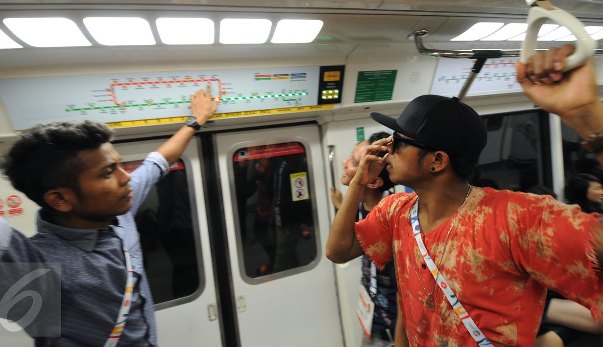 Para penggawa Garuda Muda bersantai sejenak usai melaksanakan ibadah salat Jumat di Masjid Sultan, Bugis, Singapura (5/6/2015). Zulfiandi (kiri) menunjukkan jalur MRT kepada Manahati Lestusen. (Liputan6.com/Helmi Fithriansyah)