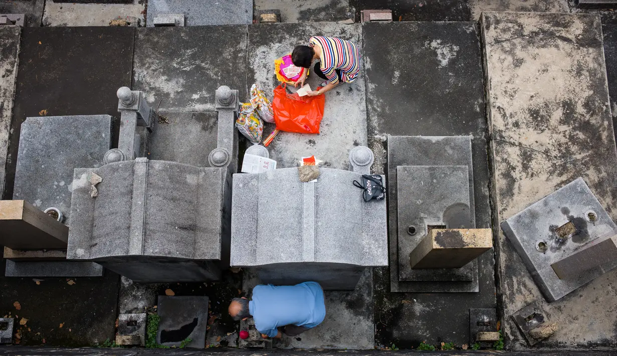 Warga membersihkan makam kerabat saat Festival Chung Yeung atau Tomb Sweeping Day di sebuah pemakaman di Hong Kong, 17 Oktober 2018. Pada saat perayaan, warga keturunan China mengunjungi dan membersihkan makam-makam leluhur mereka.  (Anthony WALLACE/AFP)