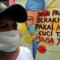 Warga berjalan melintasi mural bertema COVID-19 di kawasan Tanah Tinggi, Tangerang, Banten, Rabu (20/1/2020). Kegiatan ini dalam rangka mensosialisasikan bahaya penyebaran COVID-19 kepada warga pengguna jalan umum. (merdeka.com/Arie Basuki)