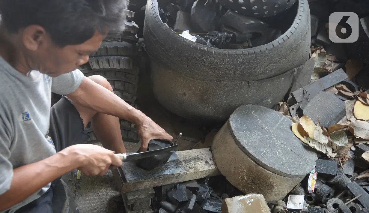 Pekerja membuat karet bushing stabilizer dan karet engine mounting khusus mobil yang terbuat dari ban bekas alat berat di Bambu Papus, Tangerang Selatan, Rabu (11/11/2020). Pada masa pendemi pemesanan karet bushing menurun hingga 50 persen kini berlahan-lahan mulai stabil. (merdeka.com/Dwi Narwoko)