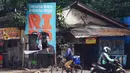 Pengguna jalan melewati baliho kampanye pasangan cagub-cawagub Jakarta nomor urut 1 Ridwan Kamil (RK)-Suswono yang rusak di Jalan Bekasi Raya, Klender, Jakarta Timur, Senin (11/11/2024). (merdeka.com/Arie Basuki)