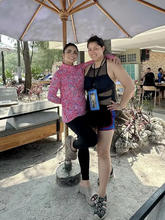 Krisdayanti juga tampil dengan baju renang yang tertutup. Dengan atasan lengan panjang bermotif dipadukan celana ketat hitamnya. [@krisdayantilemos]