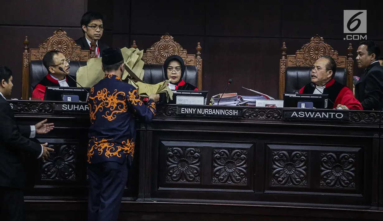 Komisioner KPU, Hasyim Asyari mengantar amplop kehadapan Majelis Hakim dalam sidang sengketa pilpres 2019 di Gedung MK, Jakarta, Kamis (20/6/2019). Keterangan mengenai jumlah lembar ini kosong. Artinya, amplop tersebut tidak pernah digunakan untuk apa-apa. (Liputan6.com/Faizal Fanani)