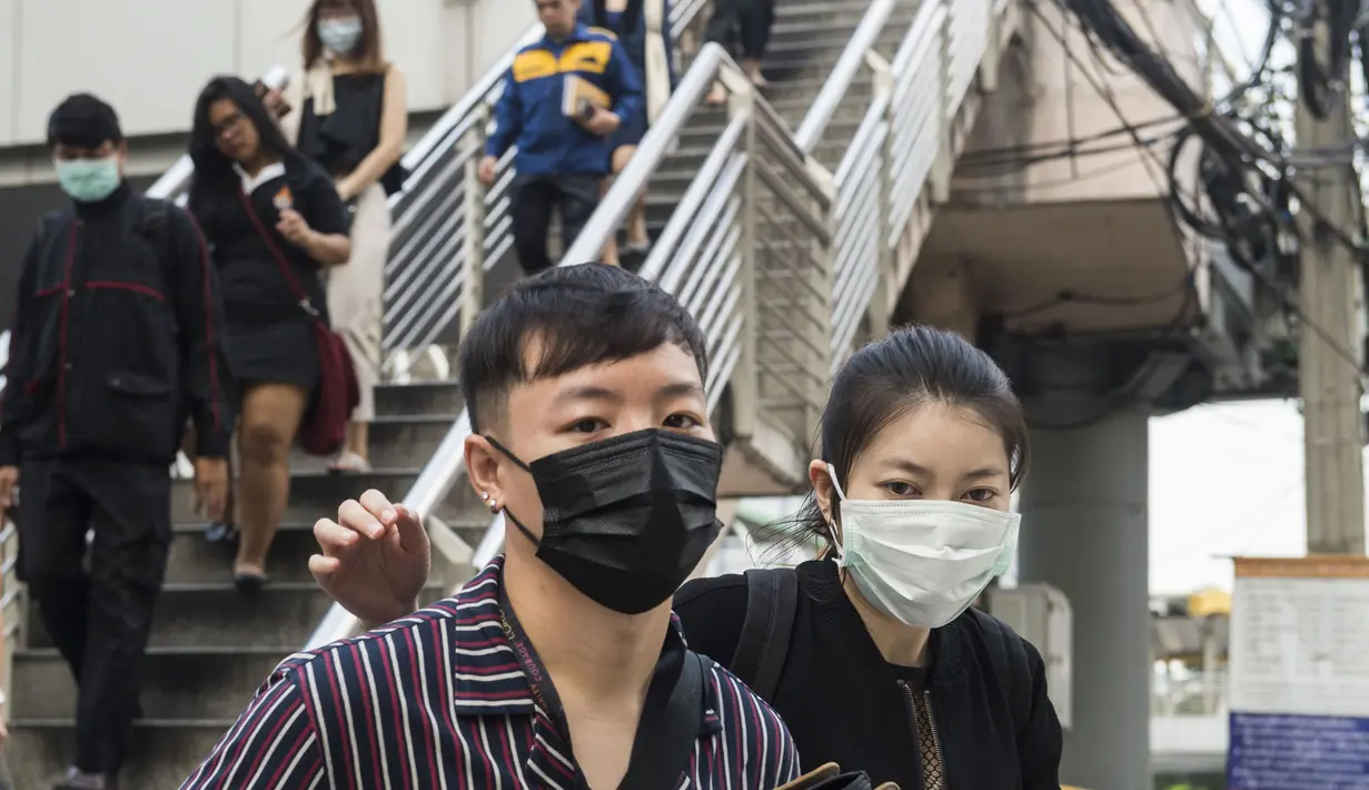 <p>Pekerja mengenakan masker usai menaiki komuter selama kabut asap menyelimuti Bangkok (16/1). Thailand telah berupaya untuk mengatasi polusi yang telah menyelimuti ibukota dalam beberapa pekan terakhir. (AFP Photo/Romeo Gacad)</p>