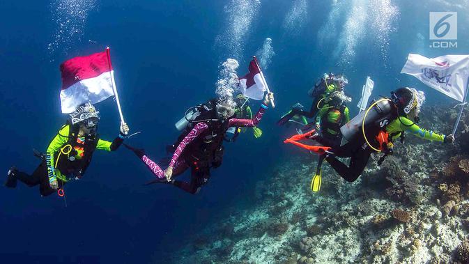 Ketua Umum Wanita Selam Indonesia (WASI), Tri Suswati Karnavian didampingi Nadine Chandrawinata dan 8 penyelam wanita membawa api obor Asian Games 2018 di perairan Pulau Piaynemo, Raja Ampat, Papua Barat, Kamis (26/7). (Liputan6.com/HO/Mabes Polri)