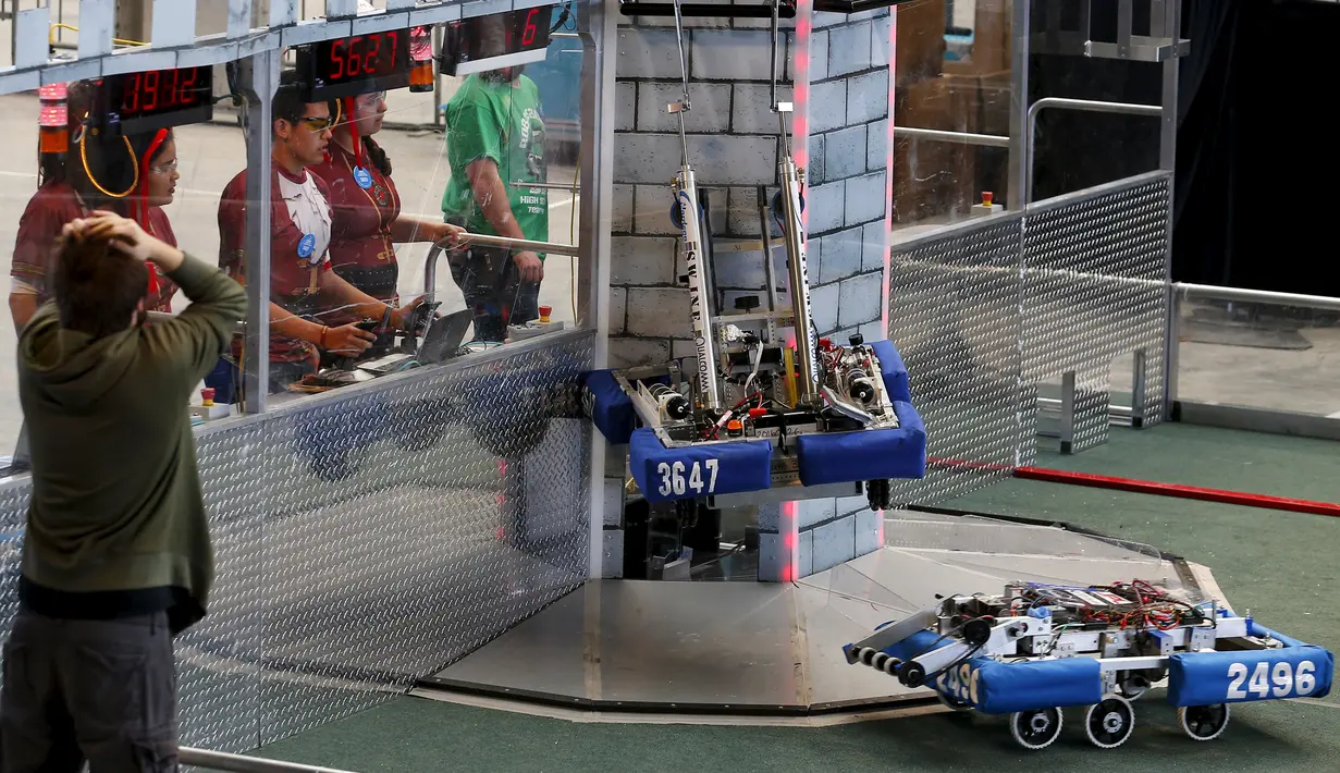 Peserta berusaha mengendalikan robot untuk mendaki sebuah kastil dalam kompetisi robot San Diego Regional FIRST Robotics di Del Mar, California (4/3). Kompetisi tahunan San Diego ke-10 ini diikuti oleh puluhan tim dari SMA di AS. (REUTERS / Mike Blake)