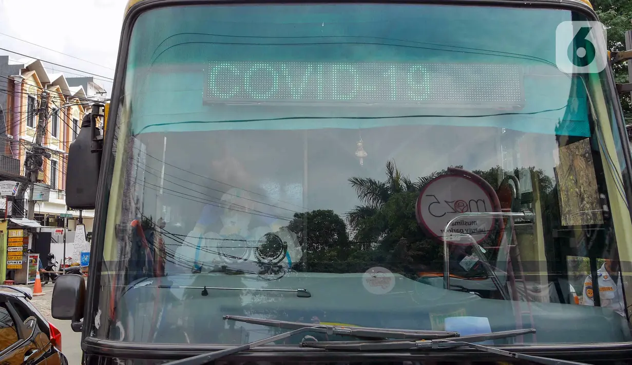 Sopir bus sekolah mengenakan APD saat akan mengantarkan pasien COVID-19 menuju RSDC Wisma Atlet di Puskesmas Kecamatan Tebet, Jakarta, Kamis (3/2/2022). Kasus COVID-19 sepekan terakhir mencapai 56.000 atau meningkat 40 kali lipat dibandingkan awal Januari lalu. (Liputan6.com/Herman Zakharia)