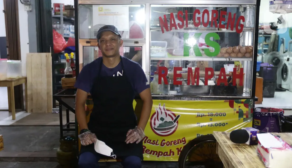 Mantan pegawai fungsional Biro Hukum Komisi Pemberantasan Korupsi (KPK), Juliandi Tigor Simanjuntak berpose di depan gerobak nasi goreng di pinggir Jalan Raya Hankam, Pondok Melati, Kota Bekasi, Rabu (13/10/2021). (Liputan6.com/Helmi Fithriansyah)