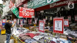 Pengunjung melihat pakaian yang dijajakan di salah satu tenant di Pasar Baru, Jakarta, Rabu (5/4/2021). Memasuki minggu terakhir bulan Ramadhan 2021, Pasar Baru tampak sepi pengunjung. (Liputan6.com/Faizal Fanani)