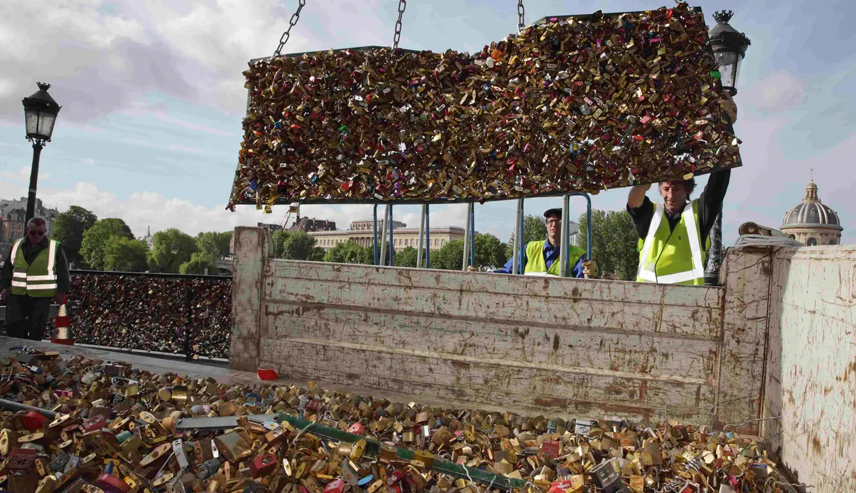 Petugas memindahkan ribuan gembok cinta, dari sisi pembatas pagar Jembatan Pont des Arts di atas Sungai Seine ke sebuah truk, Paris, Perancis, Senin (1/6/2015). (REUTERS/Philippe Wojazer)