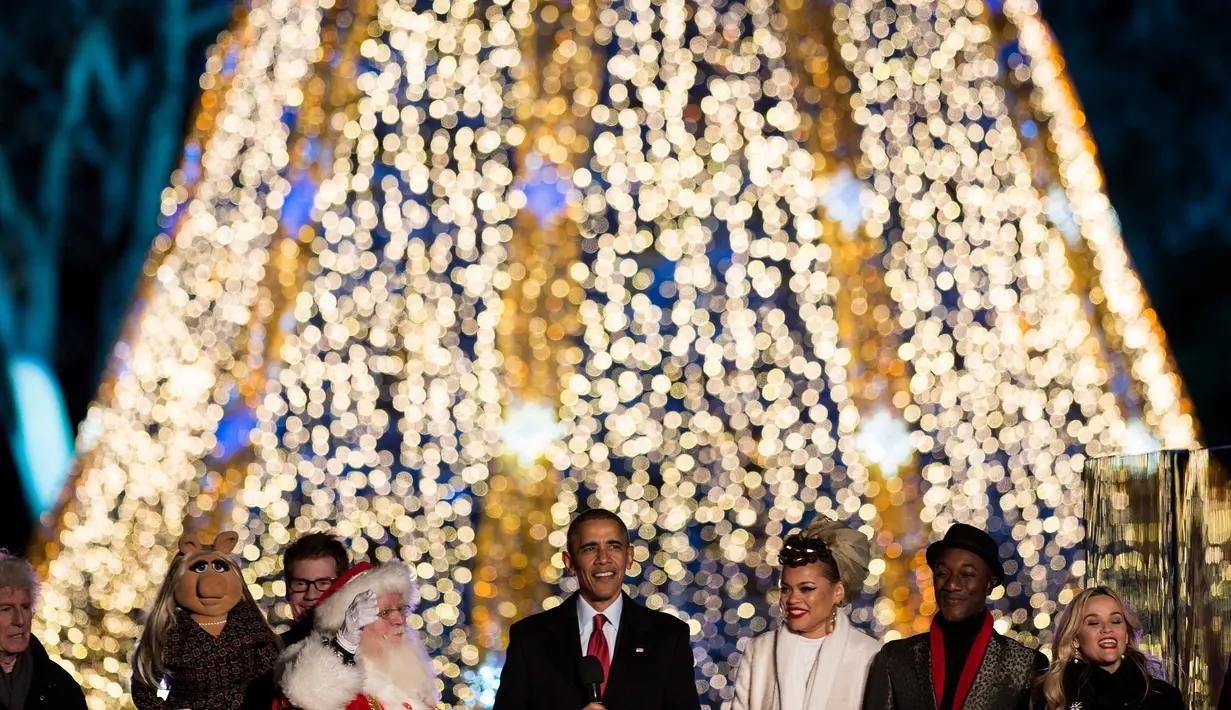 Presiden AS Barack Obama dan First Family menyanyikan lagu-lagu Natal di Taman Ellipse, dekat Gedung Putih, Washington, Kamis (3/12). Obama secara resmi menandai dimulainya musim Natal dengan menyalakan Pohon Natal Nasional  (AFP PHOTO/Brendan SMIALOWSKI)