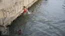 Sejumlah anak bermain dan berenang di anak Kali Ciliwung, Jakarta, Rabu (13/7). Bersihnya kali yang berada di Ibu Kota itu dimanfaatkan anak-anak sekitar untuk berenang sambil mengisi waktu libur sekolah. (Liputan6.com/Immanuel Antonius)