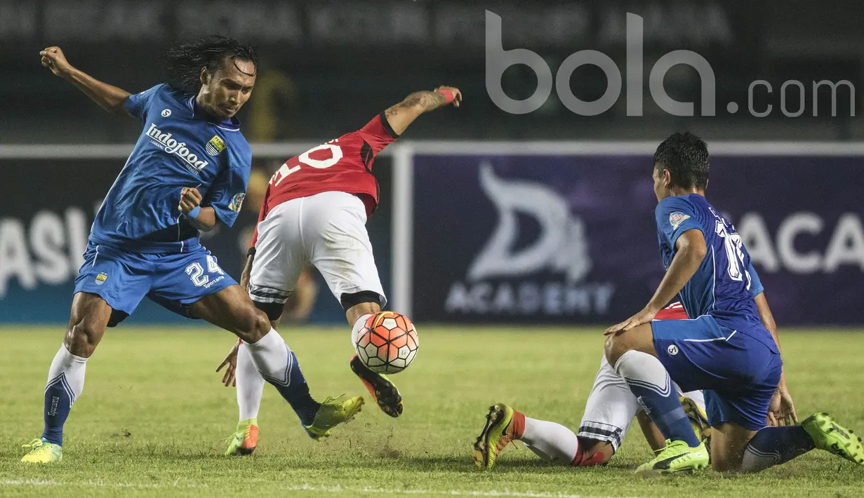 Gelandang Persib Bandung, Hariono, menjatuhkan striker Bali United, Irfan Bachdim. Laga persahabatan ini berlangsung menarik karena kedua klub saling jual beli serangan selama 90 menit. (Bola.com/Vitalis Yogi Trisna)