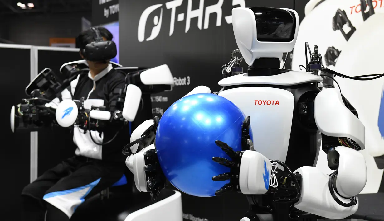 Robot humanoid generasi ketiga T-HR3 memegang bola karet saat Pameran Robot Internasional 2017 di Tokyo (29/11). T-HR3 merupakan generasi ketiga yang dikembangkan dan dirancang oleh Divisi Robot Mitra Toyota. (AFP/Toru Yamanaka)