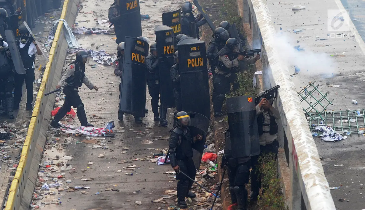 Polisi menembakkan gas air mata ke arah mahasiswa saat demonstrasi menolak pengesahan RUU KUHP dan revisi UU KPK di depan Gedung DPR, Jakarta, Selasa (24/9/2019). Demonstrasi berujung ricuh saat mahasiswa berusaha masuk ke area Gedung DPR. (merdeka.com/Arie Basuki)