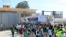Truk-truk pengangkut bantuan kemanusiaan, termasuk makanan, obat-obatan dan air, mulai memasuki Jalur Gaza yang terkepung pada hari Sabtu melalui penyeberangan Rafah yang dikuasai Mesir. (Mohammed Assad / AFP)