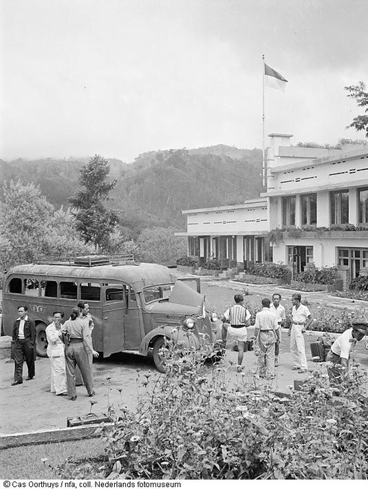 Bus dan mobil sedan era 1950 hingga 1960an sedang terparkir di pinggir jalan sekitaran Batu. (Source: jelajahmalangku.blogspot.com)