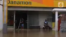 Pekerja membersihkan sebuah bank saat banjir merendam di Kawasan Bendungan Hilir (Benhil), Jakarta Pusat,  Selasa (25/2/2020). Salah satu wilayah terdampak banjir yakni kawasan Benhil hingga membuat akses jalan untuk sementara terputus.  (Liputan6.com/Angga Yuniar)