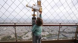 Seorang anak bermain di puncak Menara Eiffel di Paris, Prancis (15/7/2020). Puncak Menara Eiffel dibuka kembali untuk umum pada Rabu (15/7) setelah ditutup selama lebih dari tiga bulan karena COVID-19. (Xinhua/Gao Jing)