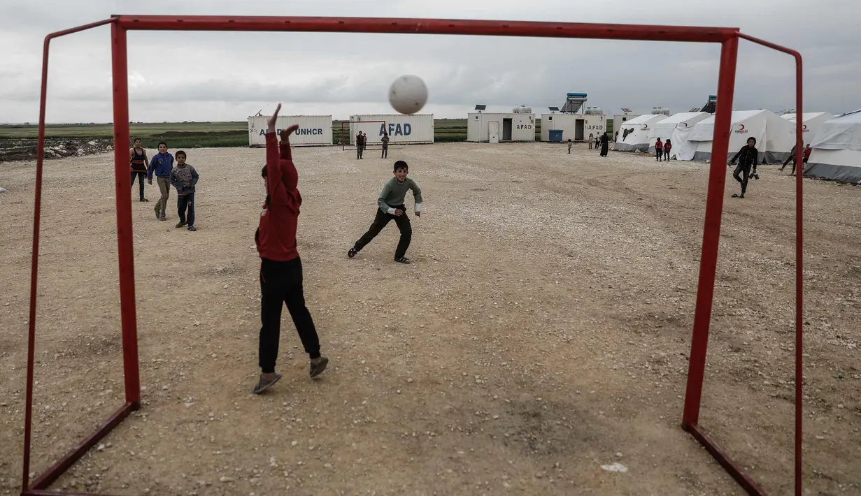 Seorang anak pengungsi Suriah menjaga gawangnya saat bermain sepak bola di sebuah kamp di al-Bil, timur dari kota Azas yang dikuasai pemberontak di Suriah utara (21/4). (AFP Photo/Sameer Al-Doumy)