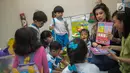 Pendiri Yayasan Pansophia Nusantara, Millie Lukito menunjukkan buku ke anak-anak PAUD CPI di Rusunawa Marunda, Jakarta (30/11). Selain memberi pendidikan kepada anak-anak, Millie mengajak orang tua mereka untuk berkreativitas. (Liputan6.com/Faizal Fanani)