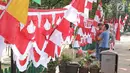 Pembeli melihat bendera dan umbul-umbul yang dijajakan pedagang di pinggir trotoar kawasan Pasar Minggu, Jakarta, Kamis (2/8). Beberapa penjual bendera menawarkan dagangannya seharga Rp15.000-Rp400.000 tergantung ukuran.  (Liputan6.com/Herman Zakharia)