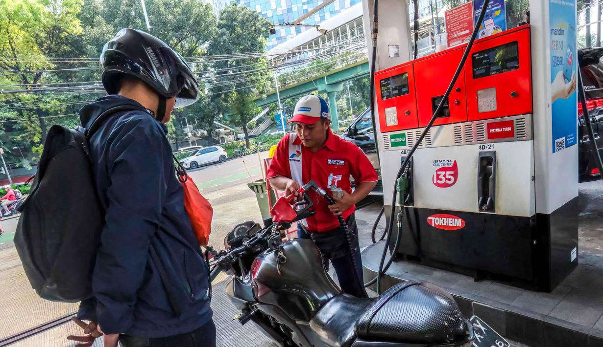 Mengacu harga BBM April 2026, semua jenis BBM nonsubsidi dan nonsubsidi tidak mengalami penyesuaian, baik Pertamax Series maupun Dex Series. Tampak dalam foto, seorang pekerja SPBU (kanan) membantu pengendara sepeda motor mengisi bahan bakar di sebuah Stasiun Pengisian Bahan Bakar Umum (SPBU), Jakarta pada Rabu 1 April 2026. (BAY ISMOYO/AFP)