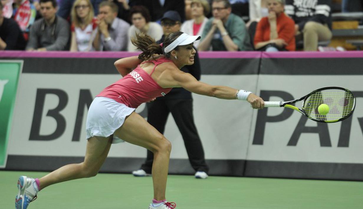 Martina Hingis berusaha mengembalikan bola pukulan Urszula Radwanska. (AFP PHOTO/PIOTR HAWALEJ)